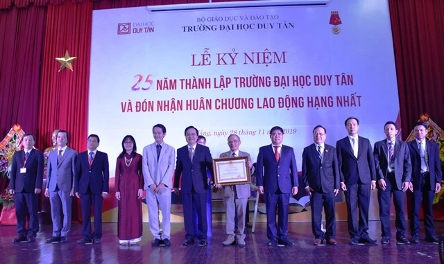 Bộ trưởng Giáo dục và Đào tạo Phùng Xuân Nhạ thừa ủy quyền Chủ tịch nước, trao tặng Huân chương Lao động hạng Nhất cho nhà trường.