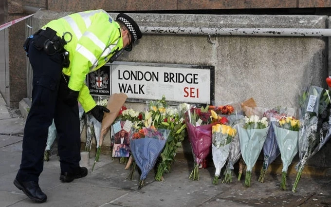 Cảnh sát đặt hoa tưởng niệm các nạn nhân gần cầu London. (Ảnh: Reuters)