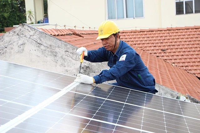 Công nhân Tổng Công ty Điện lực TP Hồ Chí Minh lắp đặt hệ thống điện mặt trời mái nhà tại một cơ sở nuôi dạy trẻ tại quận 2. 