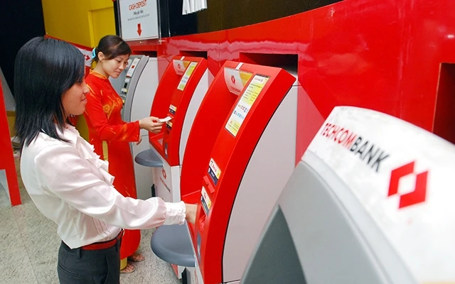 Người dân giao dịch qua hệ thống ATM tại một ngân hàng ở Hà Nội. Ảnh: NGUYỄN MINH