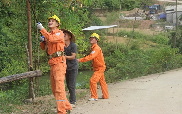 Công nhân điện lực huyện Chi Lăng kéo điện lưới quốc gia về thôn Suối Mạ, xã Hữu Kiên.