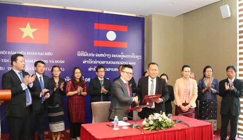 Phó Tổng Giám đốc TTXVN Lê Quốc Minh (bên trái) và Tổng Giám đốc KPL Sounthone Khanthavong ký kết Biên bản Hội đàm.