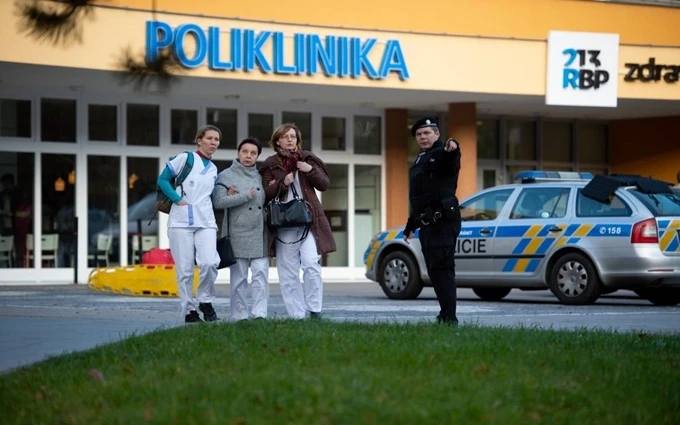 Lực lượng an ninh sơ tán mọi người ra khỏi bệnh viện ở TP Ostrava. (Ảnh: EPA)