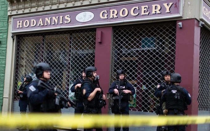Lực lượng thực thi pháp luật bảo vệ hiện trường tại cửa hàng tạp hóa sau vụ đấu súng. (Ảnh: AP)