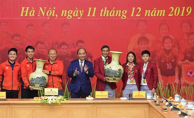 Thủ tướng Nguyễn Xuân Phúc trao quà tặng đại diện hai đội tuyển bóng đá nam và nữ.