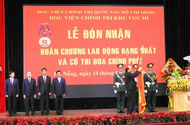 Thủ tướng Nguyễn Xuân Phúc gắn Huân chương Lao động hạng Nhất lên lá cờ truyền thống của Học viện Chính trị khu vực III.