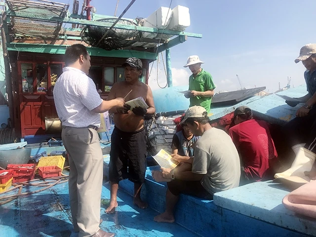 Tuyên truyền các chính sách BHXH, BHYT cho ngư dân tại cảng cá Quy Nhơn (Bình Ðịnh). Ảnh: LAN VŨ 