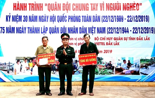 Lãnh đạo Bộ CHQS tỉnh Đắk Lắk trao tặng tiền cho các cựu chiến binh xã Cư Kbang sửa chữa nhà và mua bò giống.