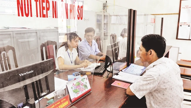Giải quyết thủ tục hành chính cho người dân tại xã Tản Hồng, huyện Ba Vì. Ảnh: MINH HÀ