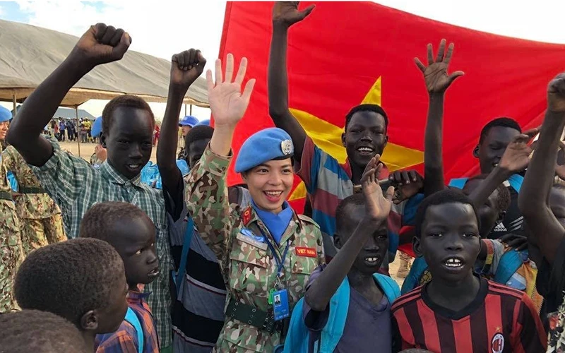 Nữ quân nhân, thành viên Bệnh viện dã chiến 2.1 của Việt Nam với trẻ em Nam Sudan. Ảnh: Mỹ Hạnh.