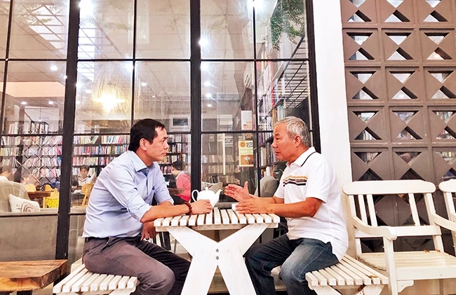 Nhà văn Trần Đức Tiến (phải) trò chuyện với nhà thơ Hữu Việt. Ảnh: VIỆT KHÔI