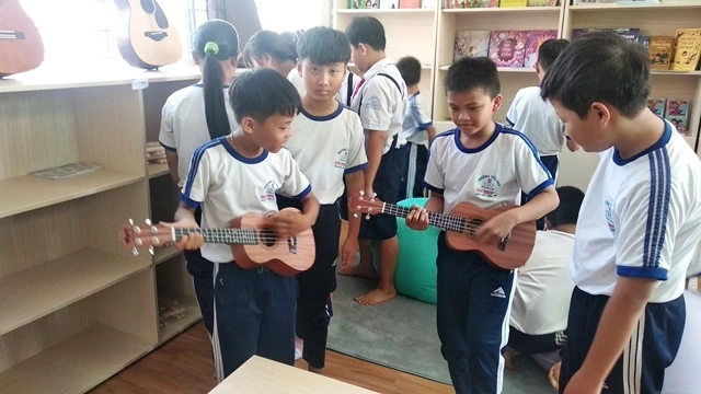 Các em học sinh thích thú với phòng âm nhạc mới đưa vào sử dụng. 