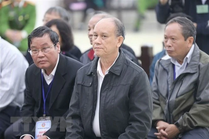 Bị cáo Trần Văn Minh (ngồi giữa, sinh năm 1955, cựu Chủ tịch UBND thành phố Đà Nẵng, giai đoạn từ năm 2006-2011) và các bị cáo tại phiên xét xử. Ảnh: Doãn Tấn/TTXVN