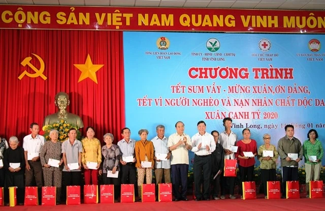 Thủ tướng Nguyễn Xuân Phúc và Bí thư Tỉnh ủy Vĩnh Long Trần Văn Rón trao quà Tết cho gia đình chính sách. 