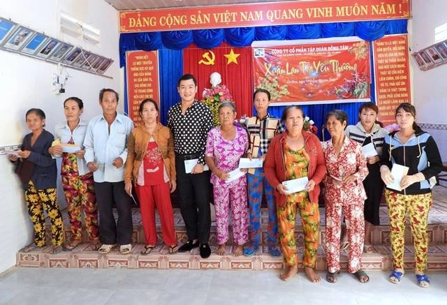 Đại diện Báo Nhân dân tại Cần Thơ và đơn vị tài trợ trao quà Tết cho dân nghèo huyện Đầm Dơi, tỉnh Cà Mau.