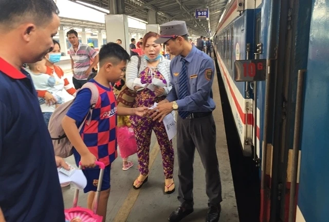 Nhân viên kiểm tra vé của hành khách trước khi lên tàu tại Ga Sài Gòn.