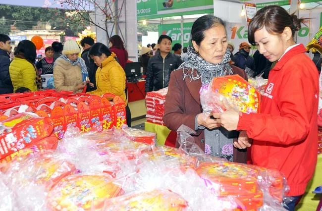 Người dân mua sắm hàng hóa tại phiên chợ Tết tổ chức tại huyện Đông Anh (Hà Nội).