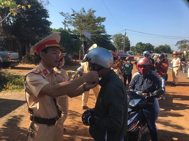 Cảnh sát Giao thông Công an Đắk Nông đổi mũ bảo hiểm mới đạt chất lượng cho người tham gia giao thông trên đường về quê đón Tết.