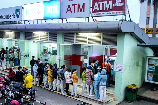Người lao động xếp hàng rút tiền tại cây ATM ở Khu công nghiệp Bắc Thăng Long, huyện Đông Anh (TP Hà Nội).