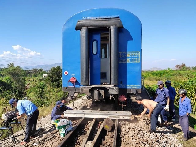 Các nhân viên kỹ thuật ngành đường sắt sử dụng thiết bị chuyên dụng nâng tàu bị trật bánh lên đường ray cũ để kéo về ga Bình Thuận.