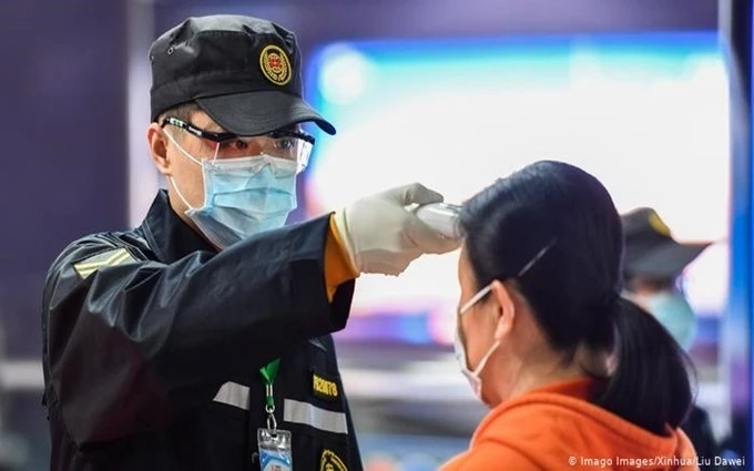 Nhân viên y tế kiểm tra thân nhiệt của hành khách tại một nhà ga ở Quảng Châu, Trung Quốc. (Ảnh: Tân Hoa xã)