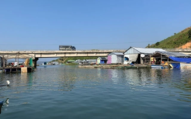 Làng chài nằm dưới chân cầu Đắk Hill, Quốc lộ 27, bắc qua hồ thủy điện Buôn Tua Sarh.