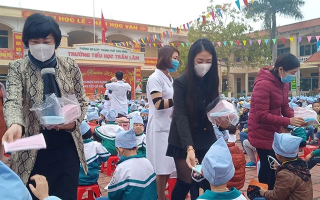 Chị Vũ Thị Thủy (bên trái) cùng cô con gái trao tặng miễn phí 1.200 khẩu trang y tế cho thày, trò Trường tiểu học Trần Lãm (TP Thái Bình) trong sáng 3-2.