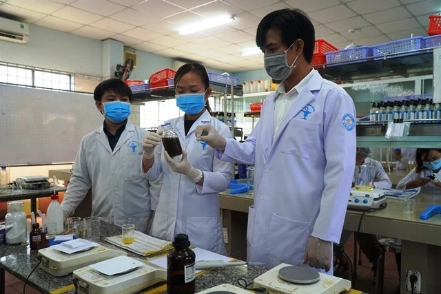 Các giảng viên đang pha chế dung dịch để tạo ra nước rửa tay sát khuẩn.