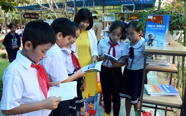 Cô giáo và học sinh Trường tiểu học Lê Văn Hiến, quận Ngũ Hành Sơn đọc sách trong Khu vườn tuổi thơ.