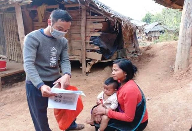 Cán bộ y tế huyện Nậm Pồ phát tờ rơi bằng hai thứ tiếng khuyến cáo về dịch bệnh nCoV đến người dân bản Nậm Ngà 2, xã Nậm Chua, huyện Nậm Pồ.