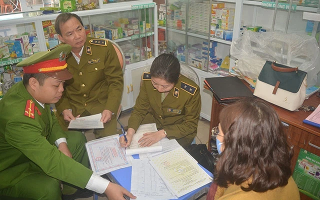 Lực lượng chức năng lập biên bản xử lý tại nhà thuốc Lan Thao.