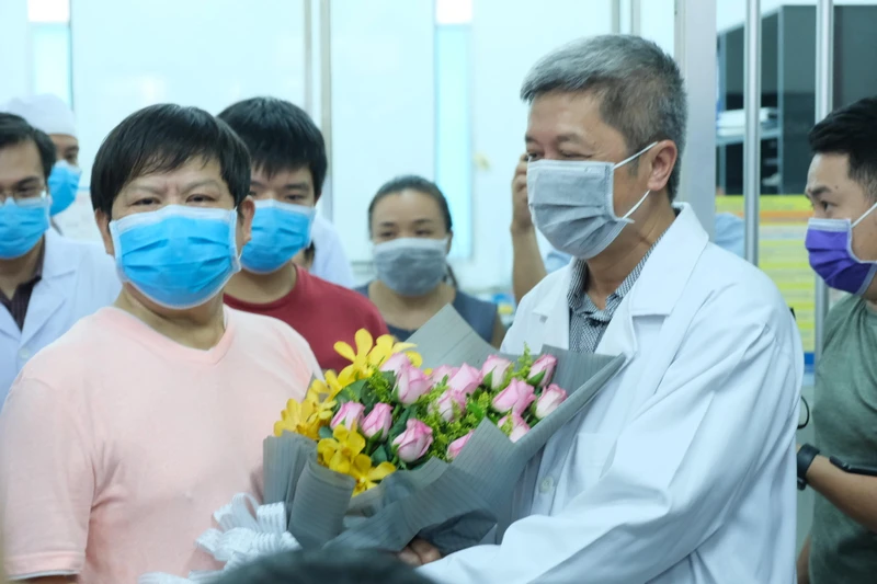 Thứ trưởng Y tế Nguyễn Trường Sơn tặng hoa chúc mừng bệnh nhân Li Ding.