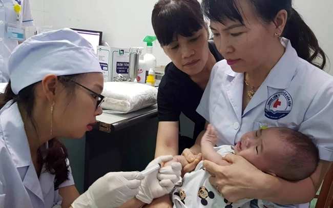 Tiêm vắc-xin phòng bệnh cho trẻ em tại Trung tâm Y tế Vân Đồn (Quảng Ninh).