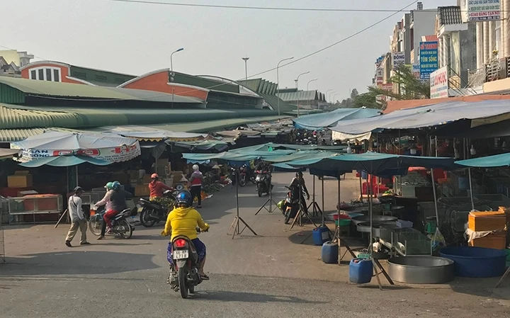 Tiểu thương chợ thị trấn Lai Vung, huyện Lai Vung đặt ô dù lấn chiếm lòng đường, gây mất an toàn giao thông đường bộ.
