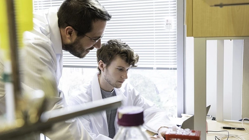 Phó giáo sư sinh học phân tử Jason S. McLellan (trái) và một nghiên cứu sinh làm việc trong Phòng thí nghiệm tại Đại học Texas ngày 17-2.