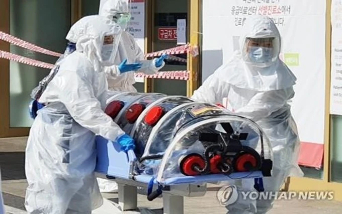 Nhân viên y tế đưa người nghi nhiễm Covid-19 đến Bệnh viện Đại học quốc gia Kyungpook tại TP Daegu, ngày 19-2. (Ảnh: Yonhap)