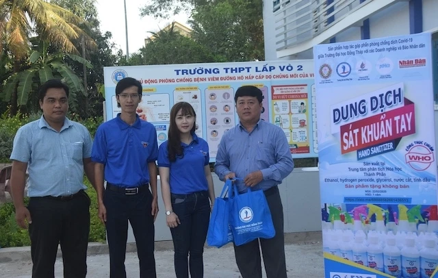Ban tổ chức và đại diện nhà tài trợ trao các chai dung dịch rửa tay khô sát khuẩn cho Trường THPT Lấp Vò 2 (huyện Lấp Vò).