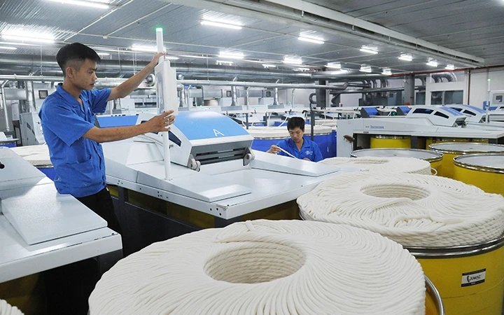 Công nhân Công ty TNHH một thành viên Dệt 8-3 vận hành dây chuyền sản xuất sợi. Ảnh: NGỌC THẠCH