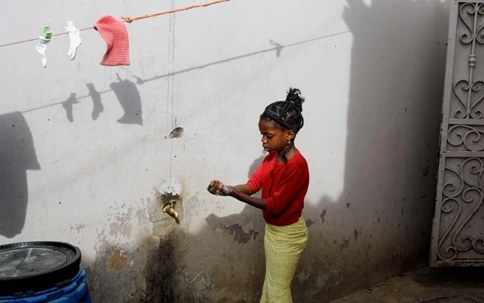 Bé gái người Senegal rửa tay trước khi vào nhà. (Ảnh: Reuters)