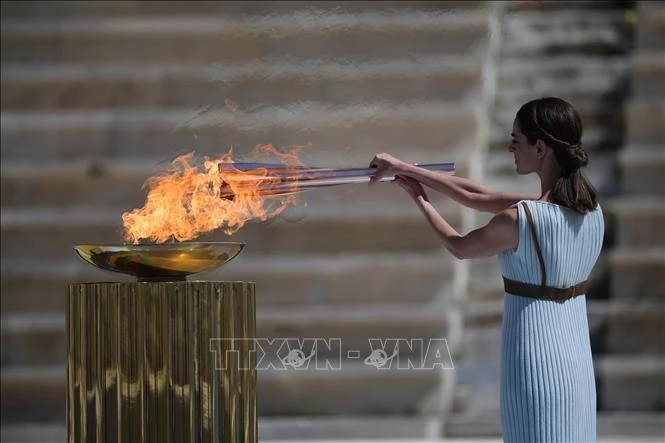 Nữ diễn viên người Hy Lạp Xanthi Georgiou trong trang phục tư tế tối cao thắp ngọn đuốc Olympic trong lễ trao đuốc cho Nhật Bản diễn ra tại thủ đô Athens, Hy Lạp. (Ảnh: TTXVN)