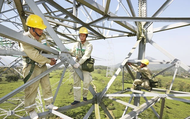 Công nhân Truyền tải điện Tây Bắc (Tổng công ty Truyền tải điện quốc gia) kiểm tra, sửa chữa đường dây 500 kV Sơn La - Hiệp Hòa. Ảnh: NGUYỄN TUẤN