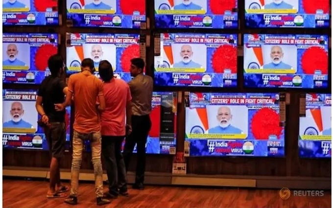 Người dân theo dõi Thủ tướng Modi phát biểu trên truyền hình ngày 19-3. (Ảnh: Reuters)