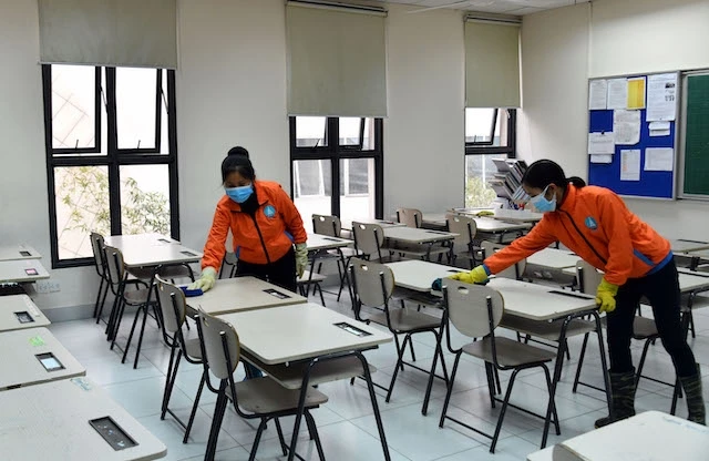 Làm vệ sinh lớp học tại Trường Marie Curie trong thời gian học sinh nghỉ để phòng, chống dịch Covid-19 (Ảnh: DUY LINH)