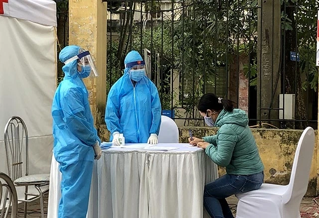 Người dân khai báo thông tin y tế trước khi xét nghiệm tại trạm xét nghiệm dã chiến tại quận Đống Đa, Hà Nội.