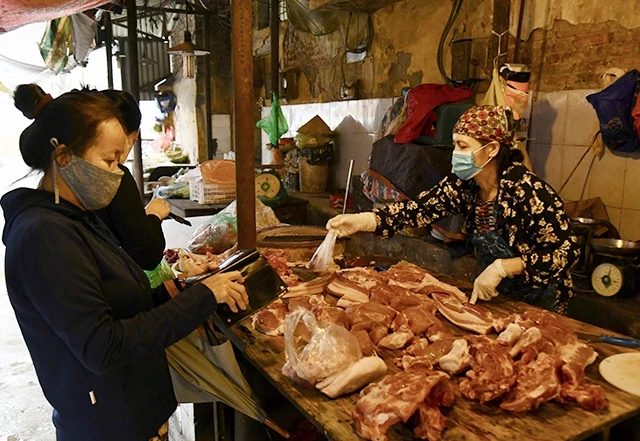 Người dân mua thịt lợn tại chợ Mai Động (quận Hoàng Mai, TP Hà Nội). Ảnh: MINH HÀ