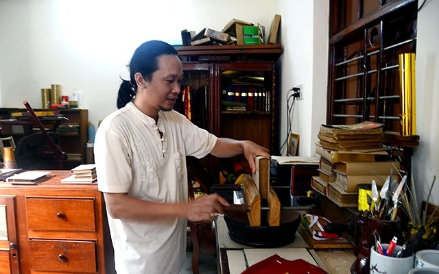  Nguyễn Ðức Khuynh bên chiếc máy kẹp sách.