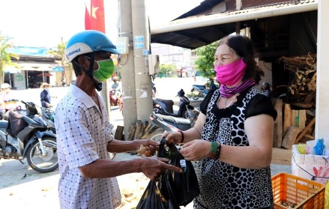 Bà Vũ Thị Tươi ở Bảo Lộc, Lâm Đồng, trao quà chia sẻ với người nghèo.