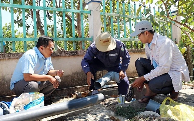 Công nhân Trung tâm Nước sạch và Vệ sinh môi trường nông thôn tỉnh Cà Mau lắp đặt đường ống dẫn nước cho các hộ dân ở xã Trần Hợi, huyện Trần Văn Thời. Ảnh: VÕ THẢO