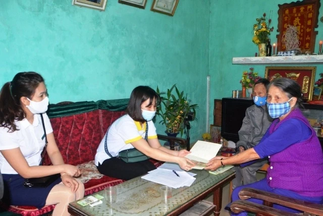 Vợ chồng ông bà Nguyễn Thị Phương ở phường Ka Long được cán bộ BHXH và Bưu điện TP Móng Cái chi trả tiền chế độ tại nhà.