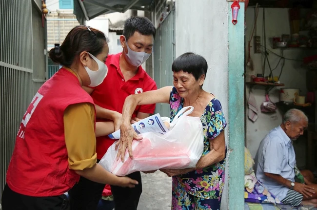Hội Chữ thập đỏ quận 6 (TP Hồ Chí Minh) và Trung tâm Công tác xã hội thanh niên phối hợp các doanh nghiệp trao quà tặng những người có hoàn cảnh khó khăn. Ảnh: HOÀNG TRIỀU